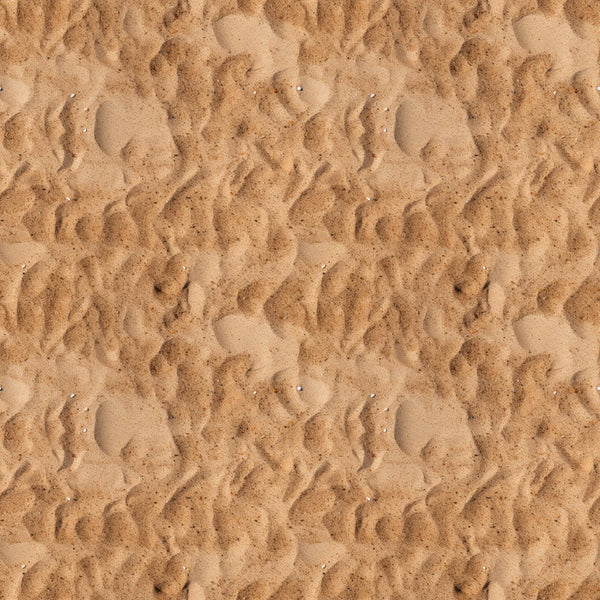 Close-up view of textured sand with ripples and small impressions, creating a wavy pattern across the surface.