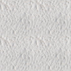 Close-up view of white sand with a pattern of small, uneven ridges and shallow depressions.