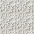 Close-up of white sand with rippled patterns and shadows.