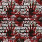 A pattern of red handprints and splatters on a white brick wall.