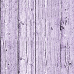 Close-up of a weathered wooden plank wall, painted in a faded lavender color, showing grain and knots.