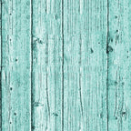 A wooden surface with a turquoise paint finish and visible grain patterns.